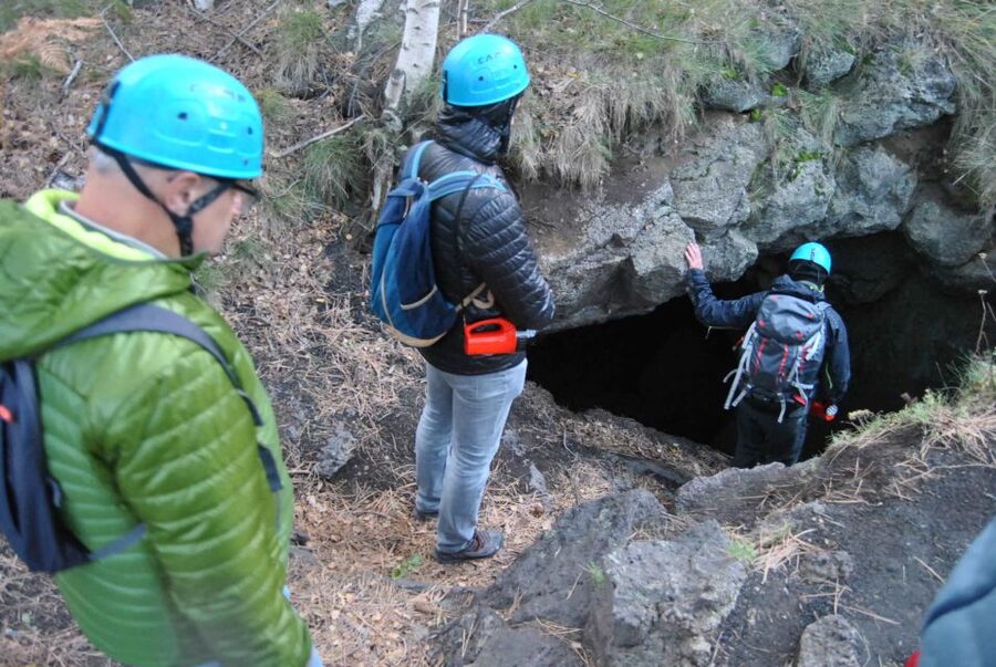 From Catania: Etna tour to the Base of the Summit Craters - Entering a volcanic cave with helmets and torches
